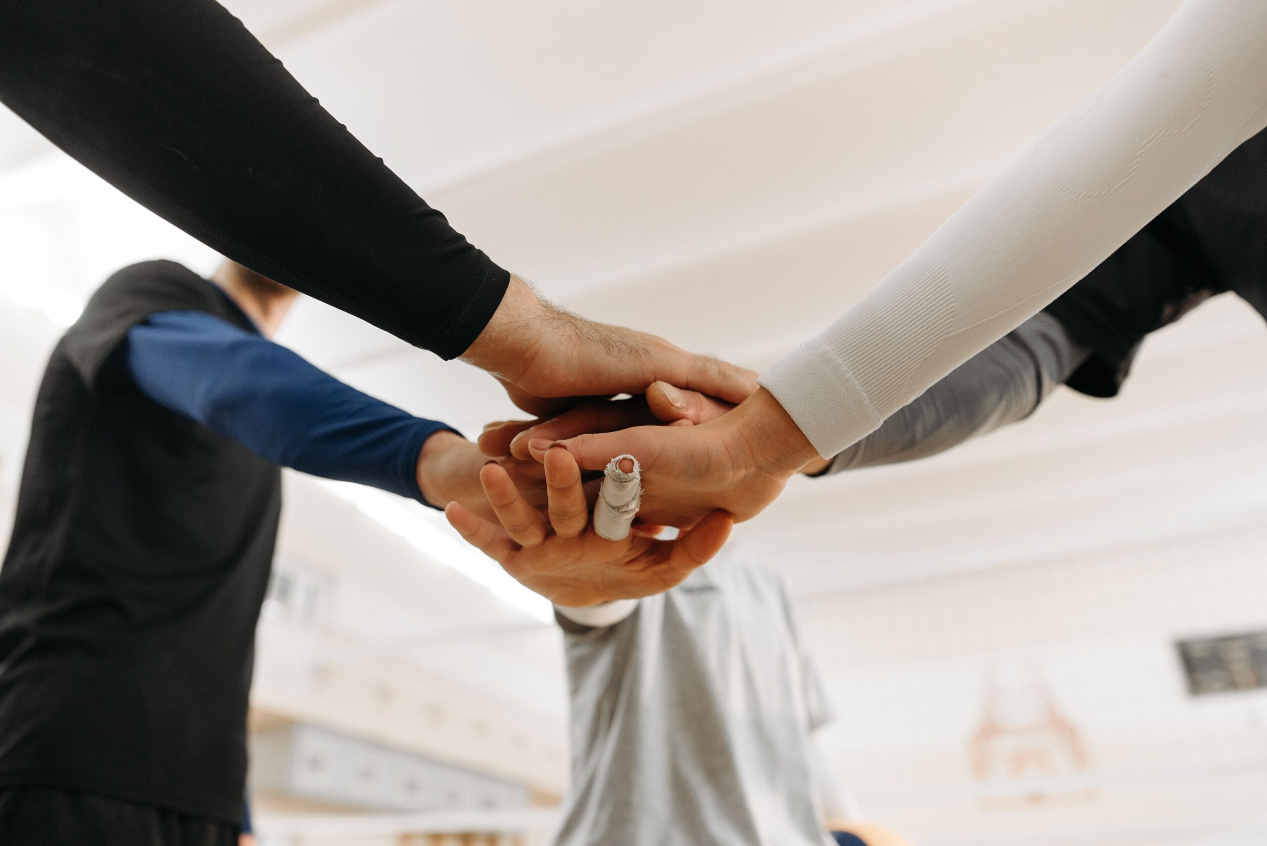 Close-up of a group engaging in teamwork, hands joined in unity.